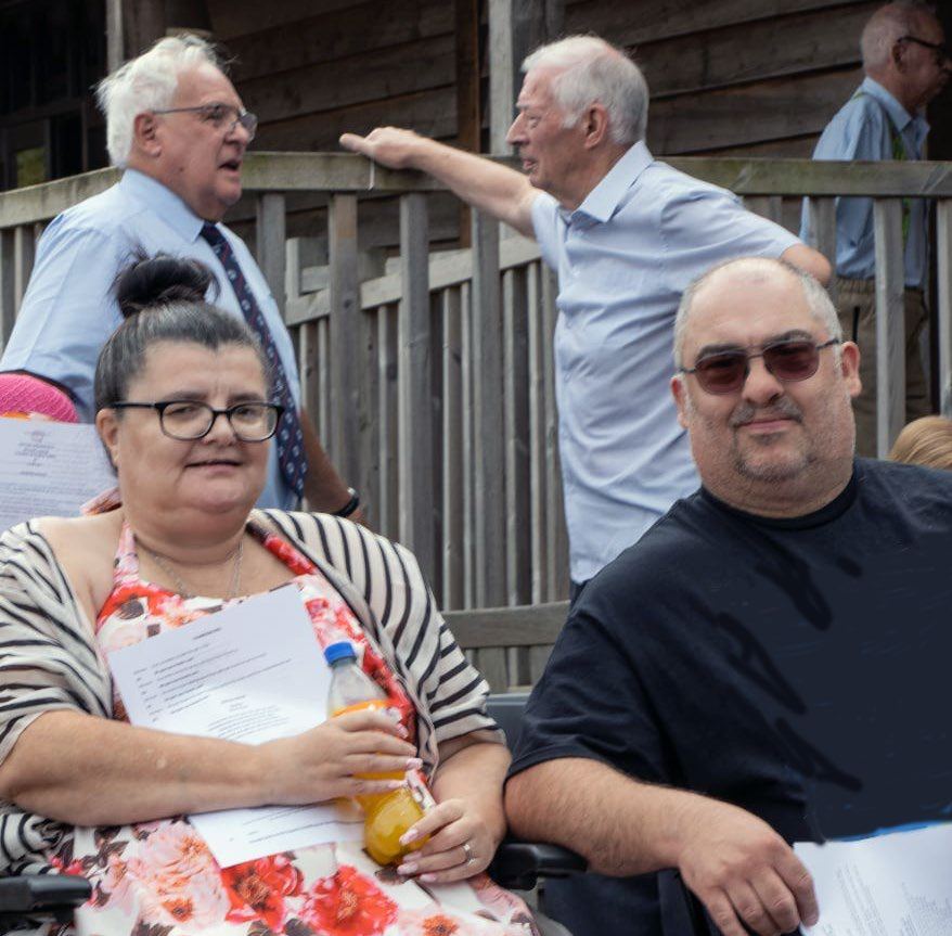 Members talking together outdoors after the service
